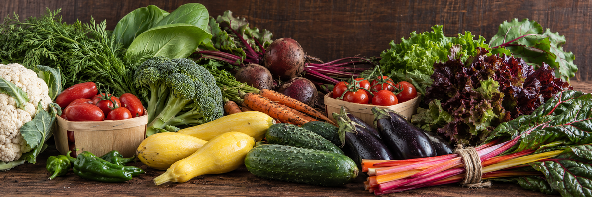 An assortment of fresh vegetables on a rustic wooden table.